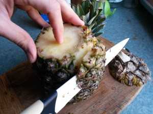 Obieranie ananasa - zacznij ścinać skórę idąc od góry do dołu.